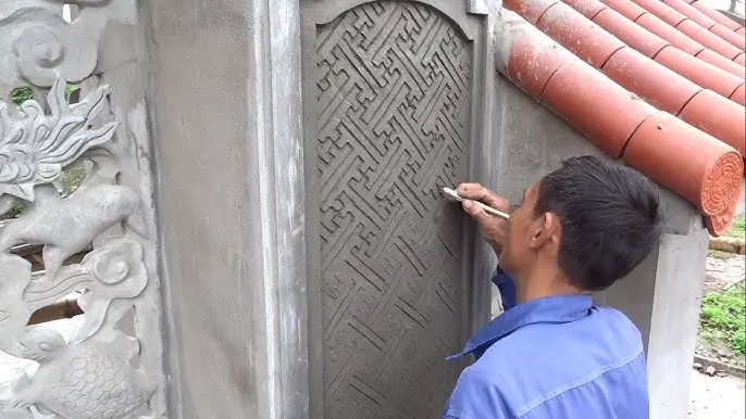 A skilled artisan hand-carving a decorative concrete panel as part of Northland Concrete’s custom designs.
